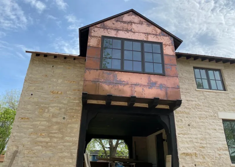 Copper metal panel facade on a stone building for Skylight Installation in La Homa